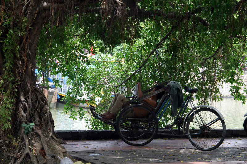 cyclo driver chillaxing by the river...