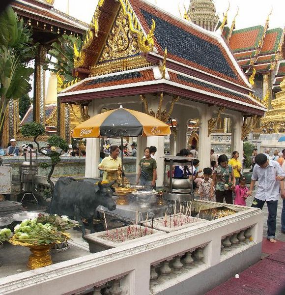 people praying and meditating around the Grand Palace