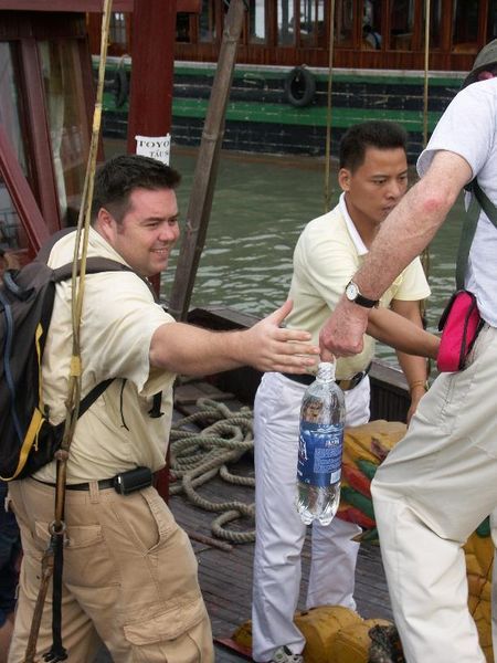 Simon our guide helping people on board our boat trip at Halong Bay