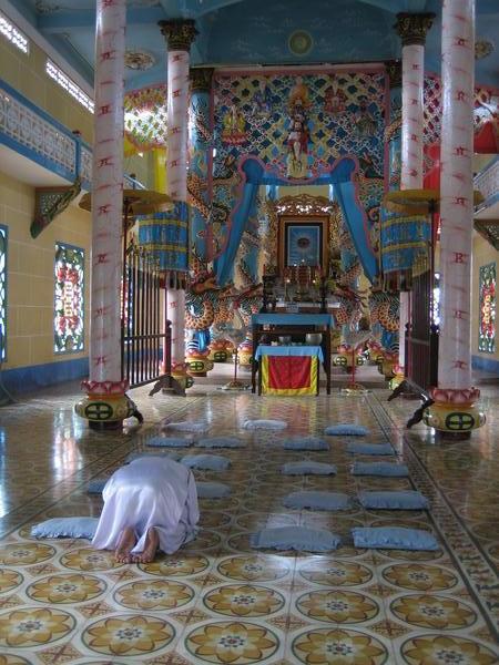 Woman praying at Cao Dai temple