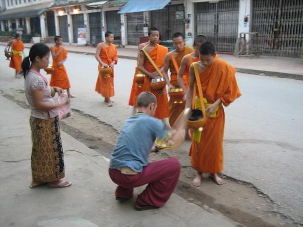 Tourist giving alms to the monks