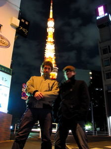 Tokyo Tower, with 2 foreignours standing in front of it.