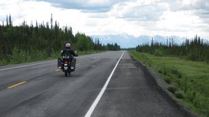 Riding the Alaska Hwy with the Alaska mountain range in the background