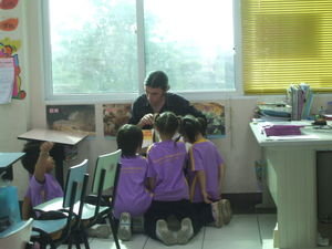Teacher Kris reading 'the Hungry Caterpillar' to his after school class