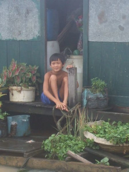 Little boy at a floating vegetable shop