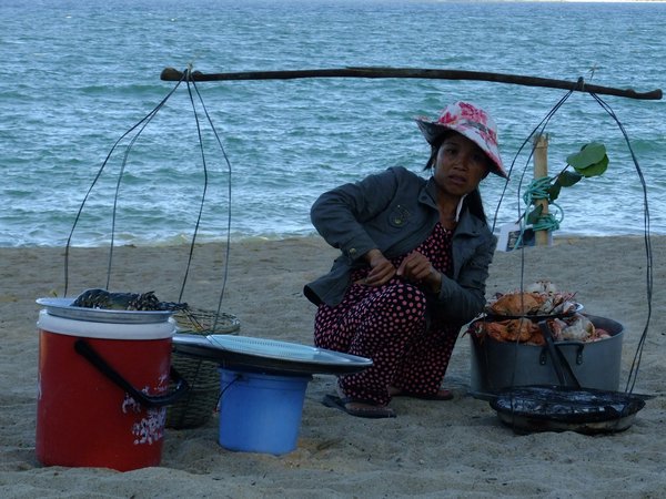 Women selling and cooking fish on the beach