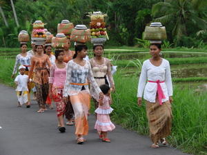 Women in traditional attire going to Purnama