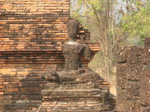 A burnt, crumbling, and decapitated Buddha