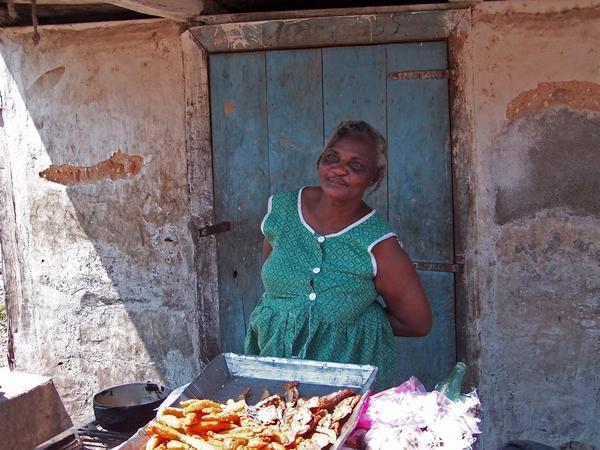 Local Haitian lady offering cooked goods for sale. 