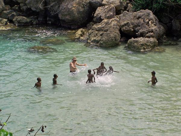 One of our Canadian guests playing with the local kids, in this great cove.