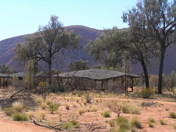 Shade hut overshadowed by Uluru