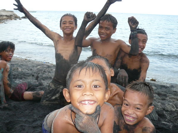 Kids in black sand on the way to Apo Island
