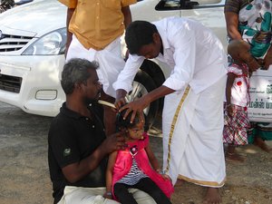 at a village temple a girls hair is shaved
