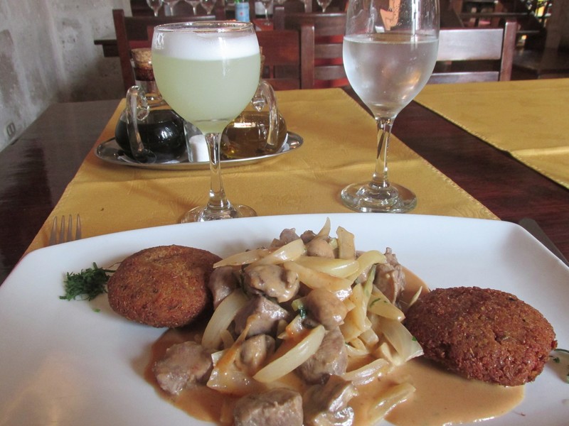 lunch of fried quinoa and alpaca stroganoff, with pisco sour