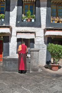Monk at Jokhang Temple using Hand Water Pump