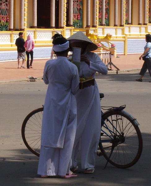Cyclists outside the Cao Dai temple at Tay Ninh