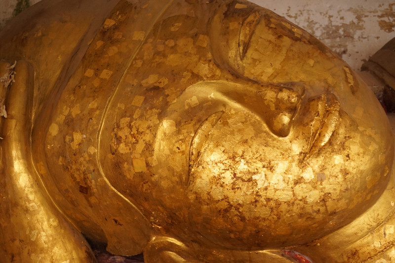 Gold leaf squares stuck to a Buddha for good karma and eternity
