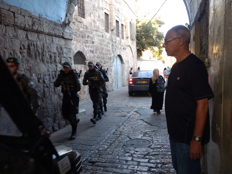 The ever-present soldiers walk by on the Via Dolorosa.