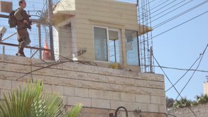 Soldier stands guard at Israeli home, Hebron.