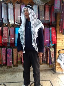 Trying on the Palestinian headgear at a nearby merchant.