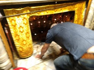 Kneeling at the Church of The Nativity, Bethlehem. The exact spot where it has been traditionally recognized as the place of Jesus 