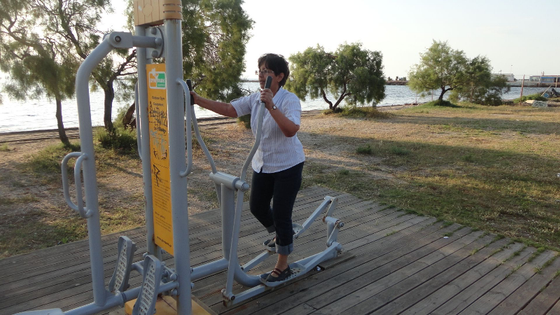 Gee using one of the outdoor exercise machines for the public on the beach.