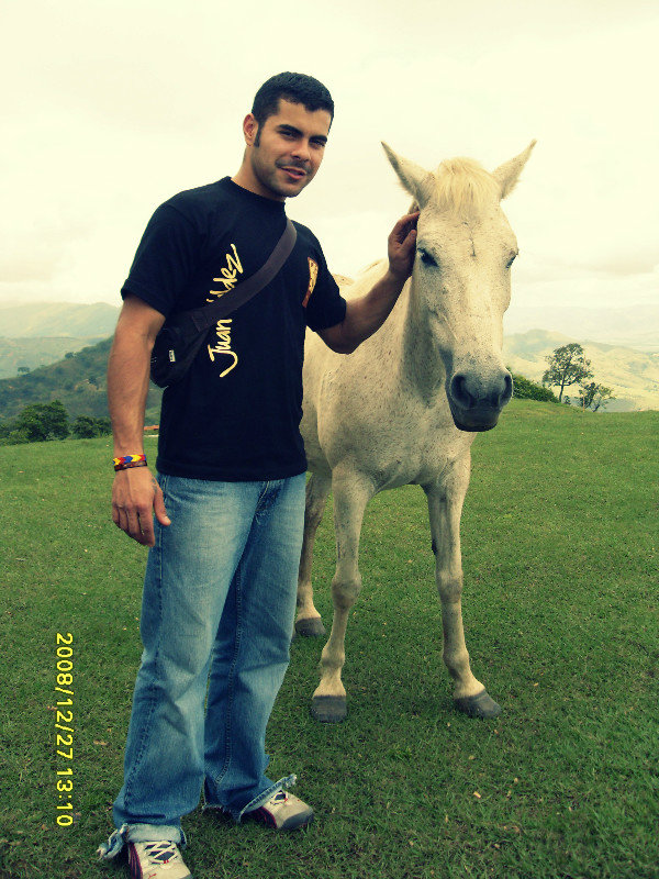 Victor posing with the a free roaming horse on the mountain side