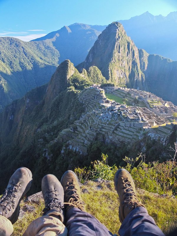 Travelers feet overlooking Machu Picchu