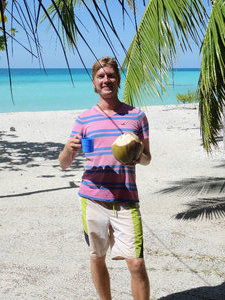 enjoying a self-picked coconut on our pension's beach at Tikehau