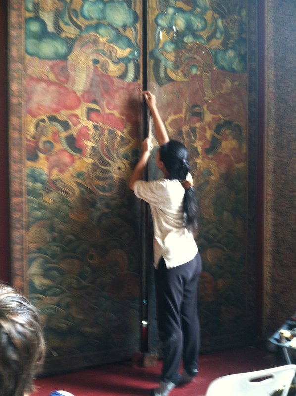 A woman restoring paintings in the reclining buddah hall