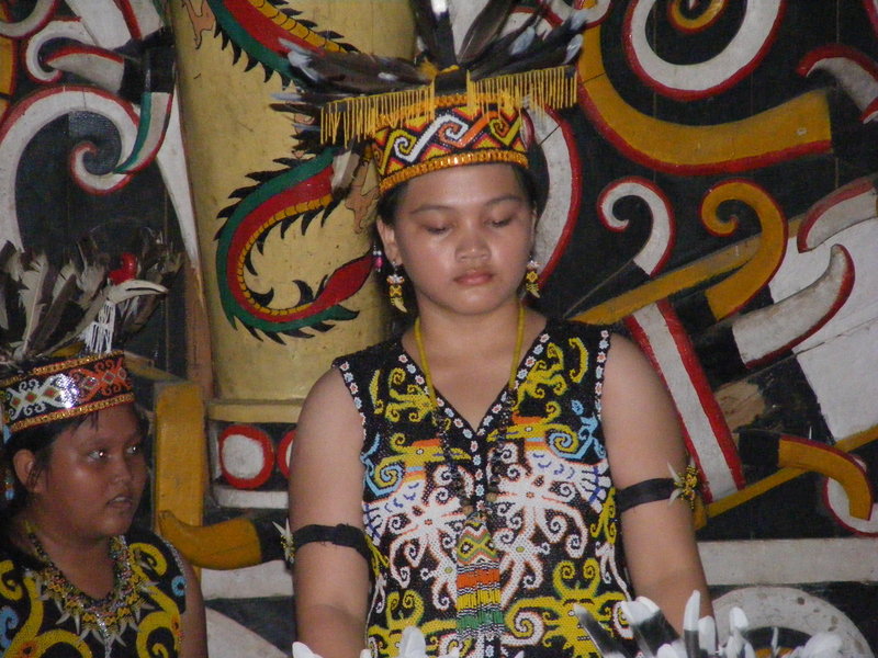 A Dayak girl dancing in the decorated longhouse