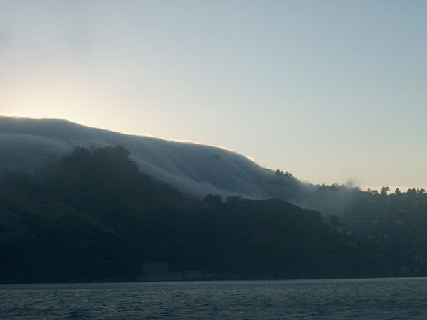 Wave of fog coming down the hill
