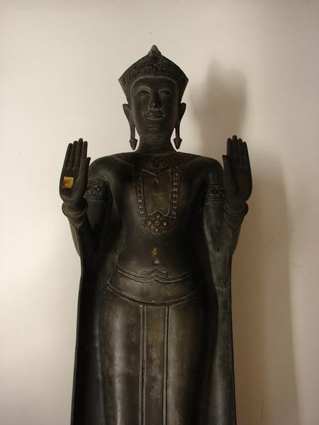 An image of the Buddha standing in the attitude of calming the ocean