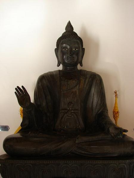 An image of the Buddha sitting cross-legged in the attitude of teaching