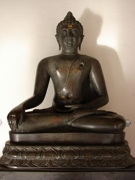 An image of the Buddha sitting cross-legged in the attitude of subduing Mara