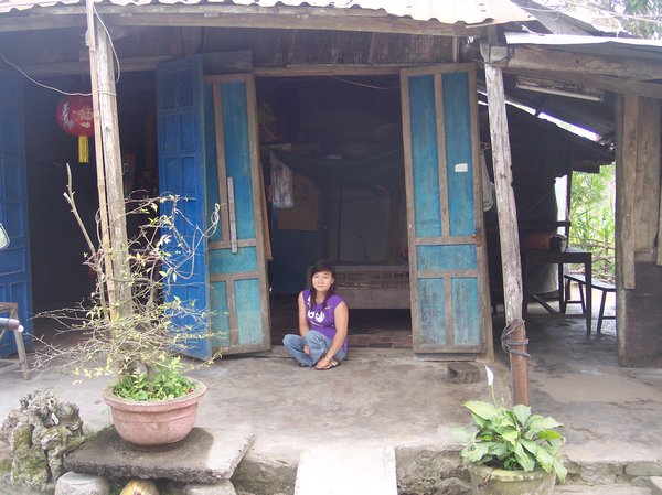 NHUNG IN FRONT OF HER OLD HOUSE