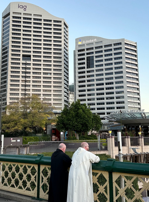 Two priests contemplating, water under the bridge