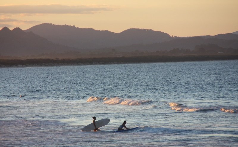Surfers at sunset Byron Bay