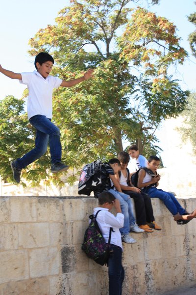 Ein paar arabische Kinder springen von einer Mauer