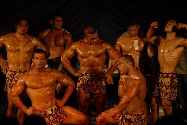 Bodybuilders die meedoen aan de Pacific Games komen hun glibberige spieren showen