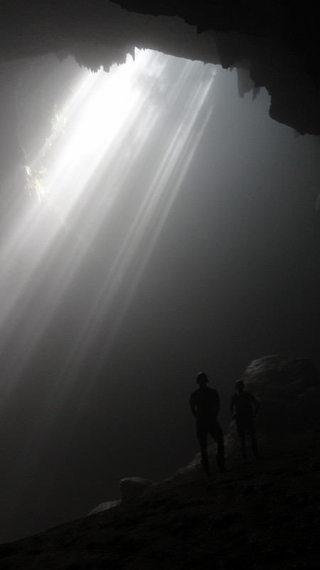 Står og beundrer lyset i Goa Jomblang