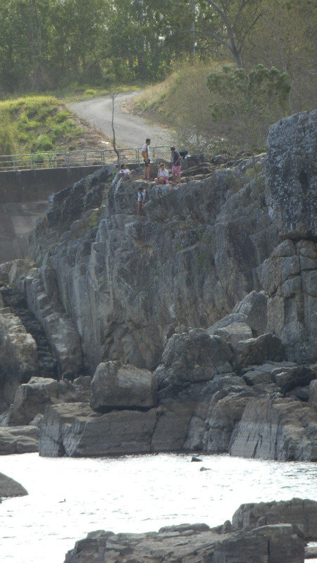 Teenagers jumping at Chicken Rock.