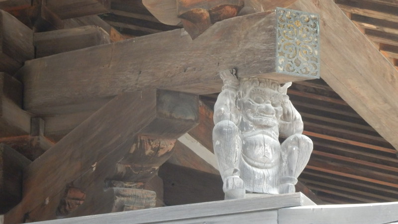 Detail of a statue holding up a roof beam.