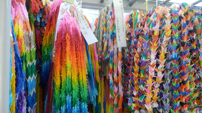 Ropes of colourful paper cranes each symbolising a wish for peace.