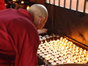 Monk lighting the butter lamps