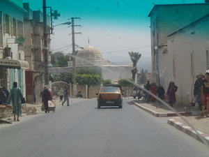Typical street scene (sans the dirty car window) with a cool mosque dome in the background.