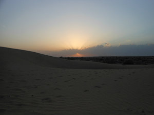 Sun disappearing over the dunes