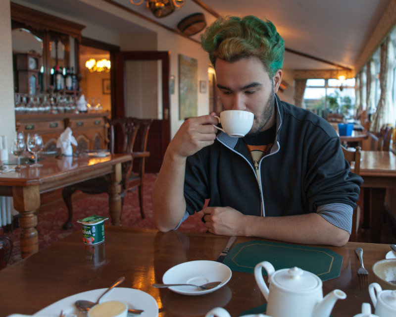 Charles sipping tea at breakfast