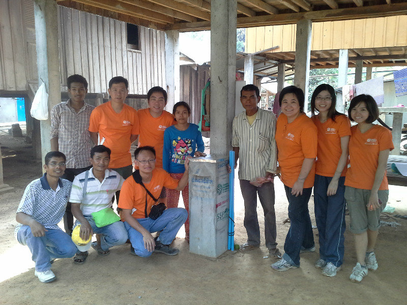 completed water filter with volunteers and village family