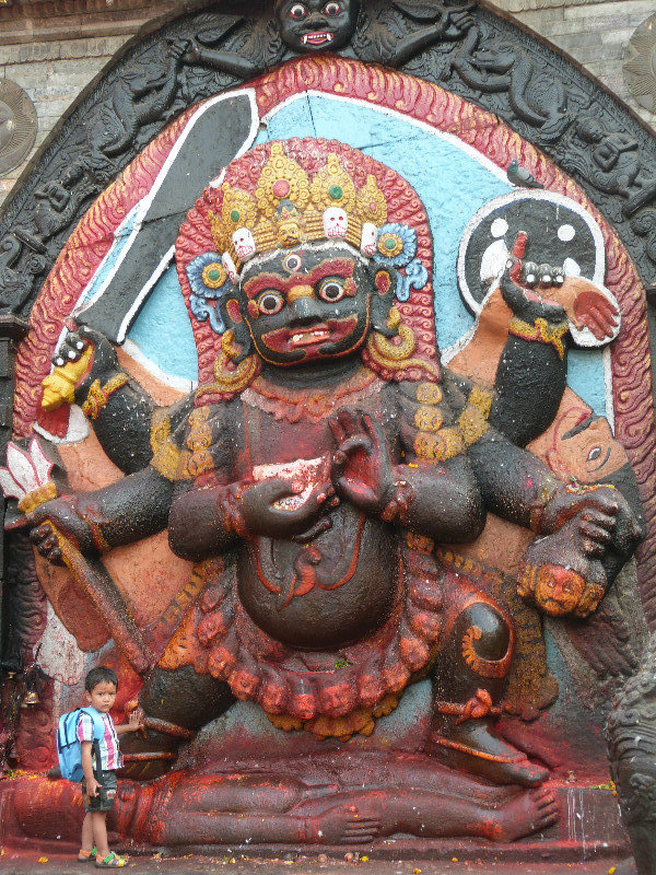 Kala Bhairab scary carving with small child